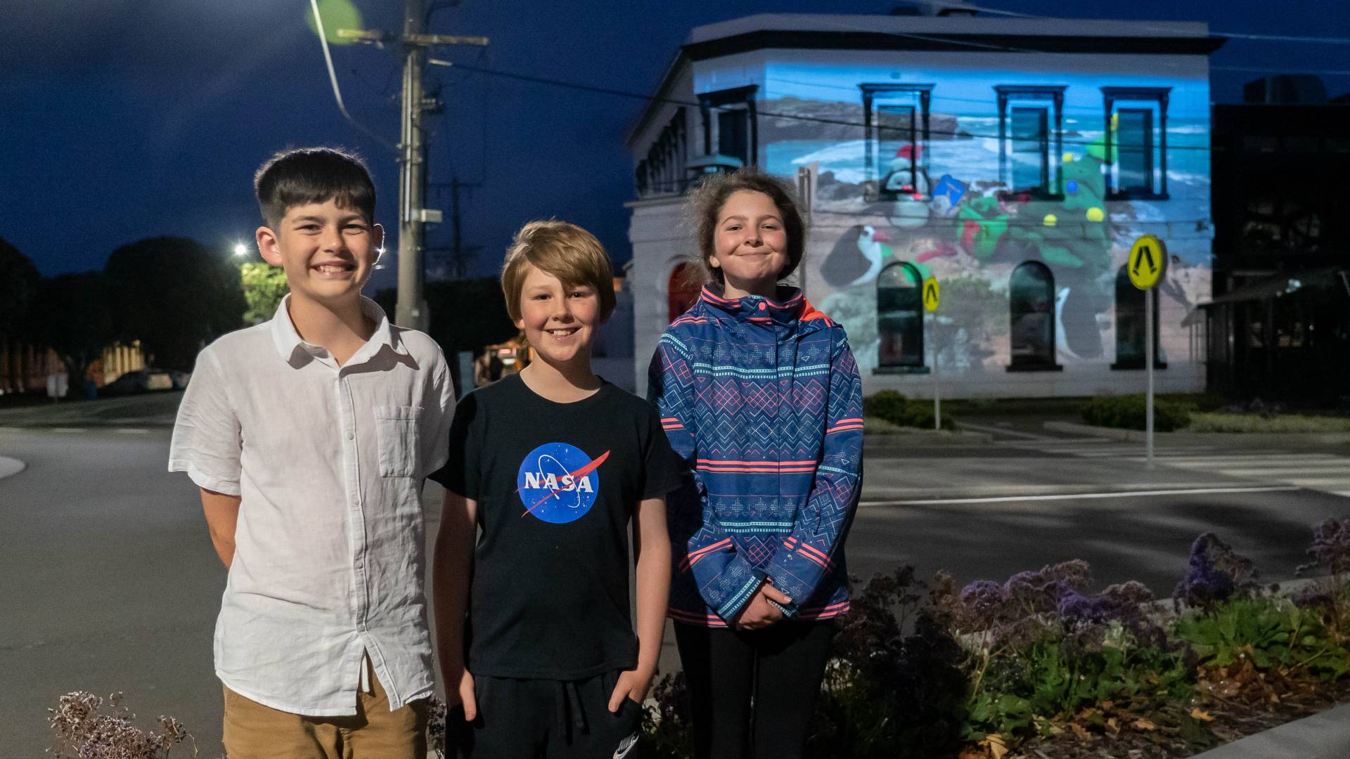 Kai Barclay, 12, Indie Price, 11 and Luca Price 13 with an animation of penguins with a Christmas tree on a Warrnambool beach