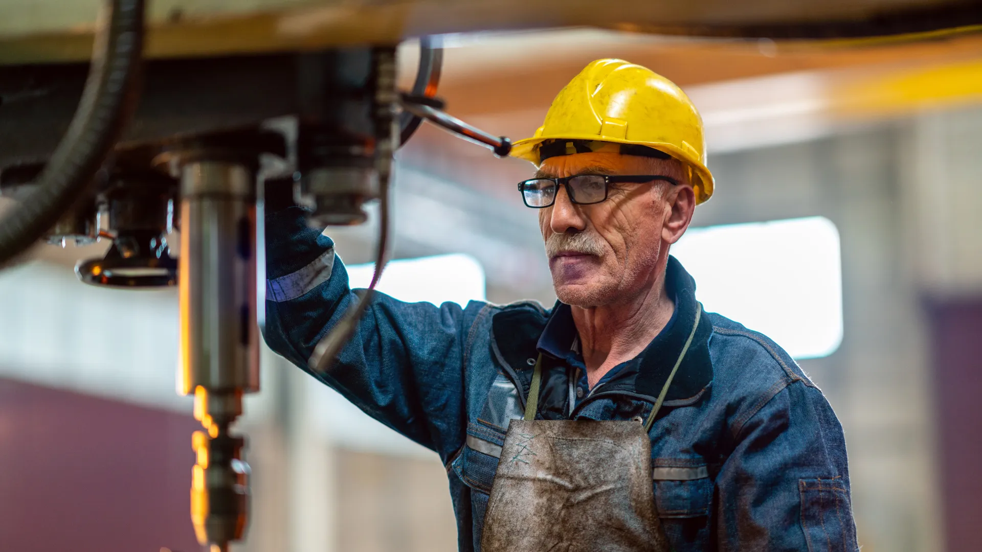 Older worker operating drill press